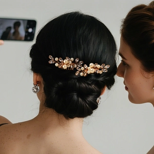 Elegant bridal hair comb set with pearls and rhinestones on a golden wedding hairstyle