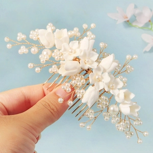 Elegant bridal hair comb with white resin flowers and pearls on golden metal pins