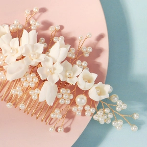 Detailed macro view of handmade white resin flowers and pearls on bridal hair comb
