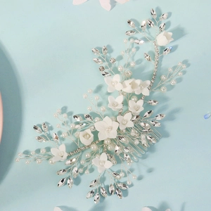 Detail of handmade bridal hair comb with white flowers, pearls, and crystal rhinestones