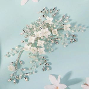 Close-up of handmade bridal hair comb with pearls, crystals and white flowers