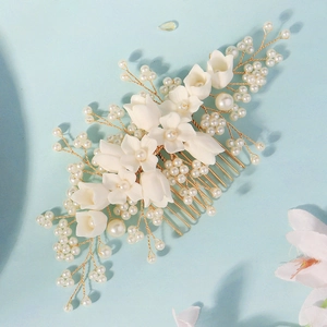 Detailed macro of bridal hair comb with white resin flowers and handmade beadwork