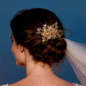 Elegant gold bridal hair comb with frosted petals and crystal beads on a model
