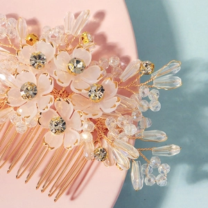 Macro detail of handmade bridal hair comb with crystal beads and gold wire flowers