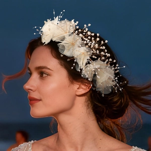 Dettaglio di cerchietto da sposa in tulle bianco con perle per acconciatura da festa