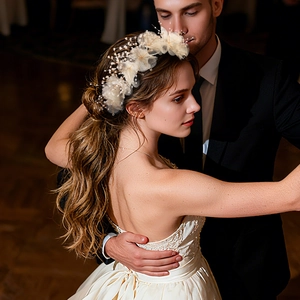 Dettaglio fascia da sposa con fiori di stoffa avorio e perline su una modella