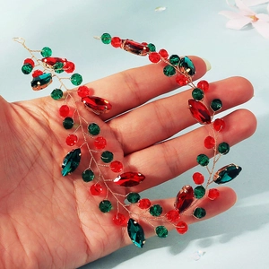 Détail d'un bandeau de Noël fait main avec cristaux rouges et verts sur fil doré