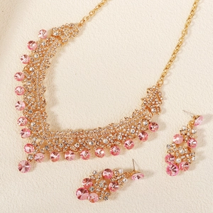 Detail of bridal necklace and earrings set with pink crystals and white rhinestones