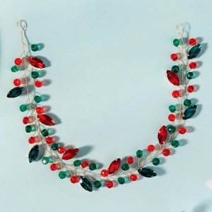 Détail du serre-tête de Noël fait main avec cristaux rouges et verts sur fil doré