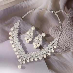 Detailed view of silver bridal jewelry set with sparkling rhinestones and white pearls