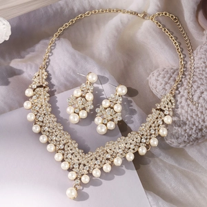 Close-up of elegant gold jewelry set with crystal diamonds and white pearls
