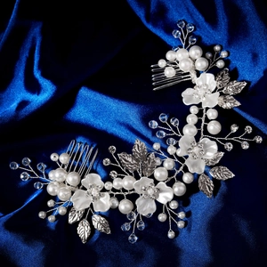 Détail d'un peigne à cheveux fleurs blanches avec perles et cristaux sur soie bleue