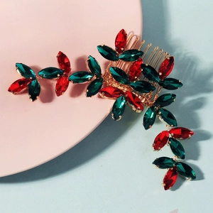 Detailed close-up of Christmas hair comb with red and green crystals on gold base