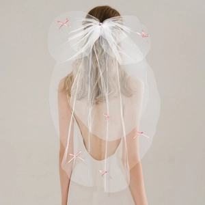 Vue détaillée d'un nœud en tulle blanc multicouche orné de rubans roses et strass rose