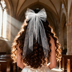 Dettaglio del velo da sposa con fiocco bianco, perle eleganti e lunghi nastri fluidi