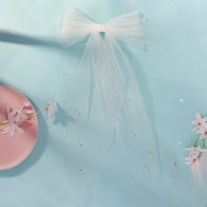 Dettaglio fiocco da sposa in rete bianca con perle su elegante sfondo blu
