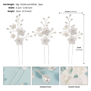 Close-up of handmade white ceramic flowers and pearls on U-shaped bridal hair pins