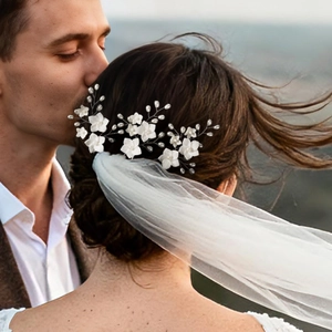 Detail of handmade bridal hair pins with white resin flowers and pearls for wedding styling