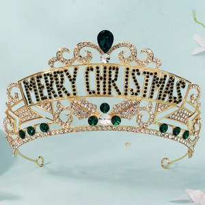 Macro detail of golden alloy Christmas crown with green crystal MERRY CHRISTMAS lettering