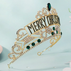 Detailed macro view of Merry Christmas gold crown with green emeralds and white crystals