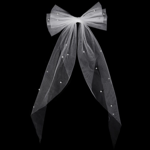 Dettaglio macro del grande fiocco in tulle bianco con perle e lunghi nastri fluenti