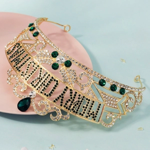 Detail of gold crown featuring emerald rhinestones and Happy Birthday lettering