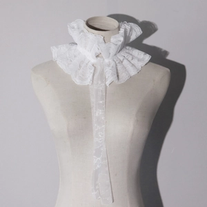 Macro detail of white lace ruffles and embroidery on a Victorian circus jabot neck collar