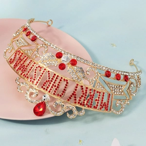 Close-up of golden Christmas crown with red Merry Christmas lettering and rhinestones