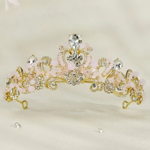 Detailed view of golden princess crown with pink beads and sparkling crystal rhinestones