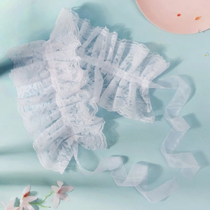 Detailed view of layered white lace ruffles with sheer organza ribbons for costumes