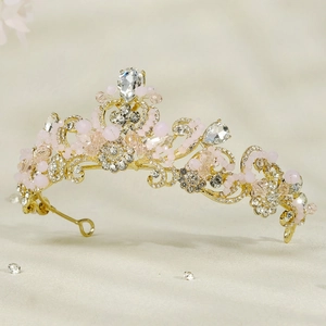 Detailed macro view of the golden bridal crown with pink crystals and clear rhinestones