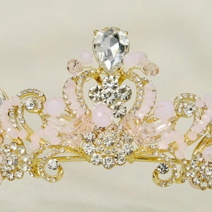 Macro detail of golden bridal tiara with pink beads and sparkling crystal teardrop stone