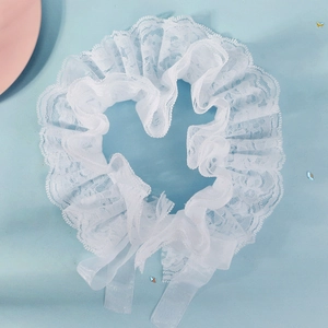Macro view of tiered white lace neck ruff and translucent ribbon tied in heart shape