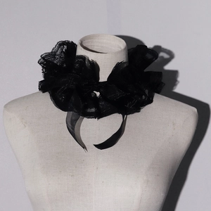 Macro shot of layered black lace ruffle collar with sheer organza and decorative ribbons