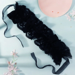 Detail of black lace ruffle collar with sheer chiffon ribbons on a pastel background