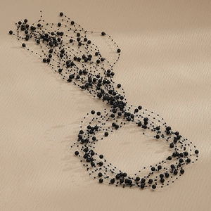 Detail view of multilayer black beaded bridal hairband with handcrafted pearl accents
