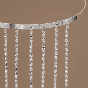 Détail macro du serre-tête à franges argentées montrant le sertissage des strass