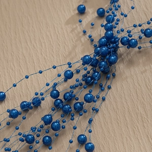 Macro shot of deep blue glossy pearls with tassels for bridal hair accessories