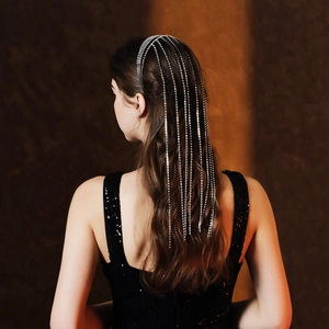 Serre-tête élégant à pampilles en strass argenté sur femme aux cheveux bouclés