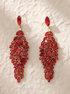 Detailed close-up of red crystal bridal earrings with marquise-cut gems on stone