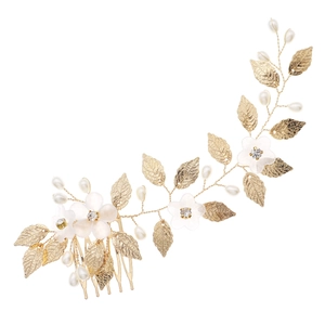 Detail view of golden metal leaves and white resin flowers hair comb with pearls