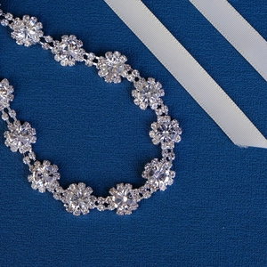 Ceinture de mariée de luxe avec fleurs de cristal argentées et perles sur fond bleu