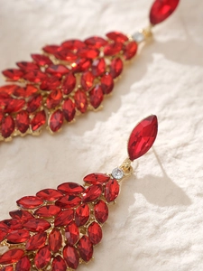 Detailed close-up of vintage bridal drop earrings with red marquise-cut crystals and gold
