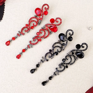 Macro shot of vintage baroque teardrop earrings with crystals in red and black colors