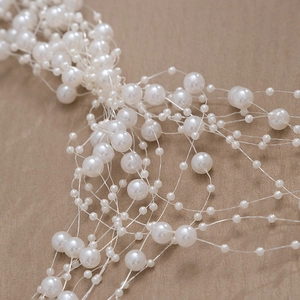 Close-up of white handmade faux pearls in mesh design for wedding hair accessories