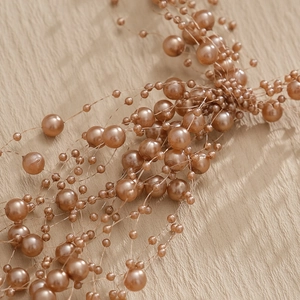 Detailed close-up of champagne gold pearl floral spray for wedding and hair decoration