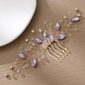 Detail of handmade gold wire hair comb with purple crystals and sparkling rhinestones