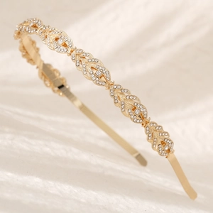 Close-up of golden headband featuring sparkling rhinestones and openwork leaf design