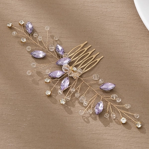 Close-up of handmade bridal hair comb with purple crystals and gold wire beads