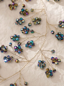 Vue détaillée d'un serre-tête de mariée fait main avec perles et branches dorées